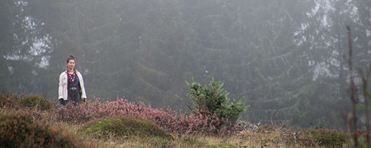 Pfadfinderin im Nebel auf einem Hügel.